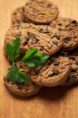 Freshly Baked Chocolate Chip Cookies on a Wooden Board With Green Garnish