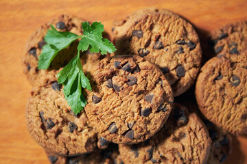 Freshly Baked Chocolate Chip Cookies on a Wooden Board With Green Garnish