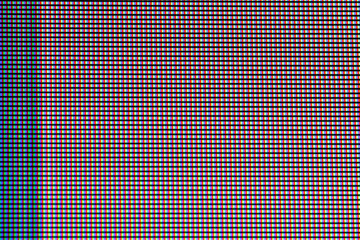 A macro view of a screen showing individual red, green, and blue pixels arranged in a grid pattern. The image captures the vibrant colors and intricate details at a close scale.