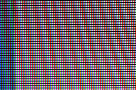 A macro view of a screen showing individual red, green, and blue pixels arranged in a grid pattern. The image captures the vibrant colors and intricate details at a close scale.