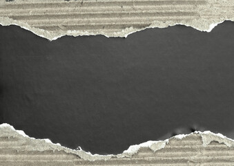 Rough torn cardboard paper background with ripped edges and dark copy space.