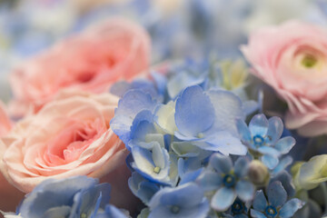 Obraz premium Macro Close Up of White Ranunculus with Blue Hydrangea and Peach Roses Bouquet