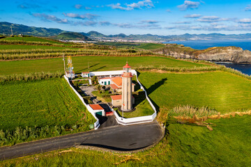 Aerial view of Cintrao lighthouse on a grassy headland by the Atlantic Ocean, Sao Miguel, Azores © Leonid