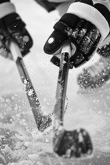 Hockey player in action, gliding on ice with sticks and snow flying in dynamic winter scene