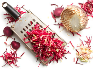 A grater full of shredded beets sits on a white table