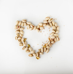 Heart made of pistachios on white background, copy space