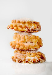 A stack of cottage cheese cookies with sugar on a white background, close-up