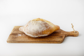 Farmer's bread lying on a wooden board, side view, space for text.