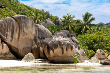 Woman on a Tropical Beach with Granite Boulders and Palm Trees