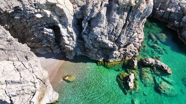 Aerial drone cinematic video of beautiful beach of Traganou with amazing sea caves and turquoise crystal clear sea next to massive popular beach of Afantou, Rhodes island, Dodecanese, Greece