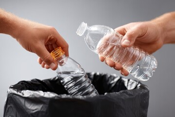 Placing a plastic bottle in a garbage bag