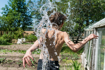 A teenage boy is doused with water