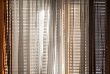 The window in the room is covered with blinds and curtains