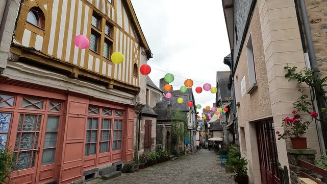A charming old street in France lined with half-timbered houses. Colorful lanterns hanging above cobblestone street in charming Brittany place. 