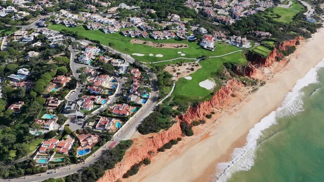Luxury Living in the Golden Triangle: Cinematic 4K Aerial of Vale do Lobo Royal Golf Course and the Iconic Crimson Cliffs of Praia do Trafal, Algarve, Portugal