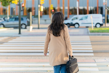 Businesswoman crossing urban street on a busy day