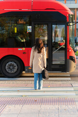 Woman standing waiting to cross as public city bus transport