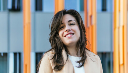 Smiling woman standing against in front of an office building background
