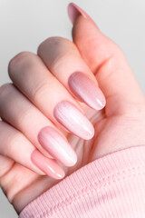 Manicure, feminine hands, glossy nude nails highlighting elegant nail art, smooth skin texture and modern beauty salon styling.