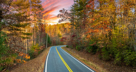 Peaceful mountain road in North Carolina during peak fall season at sunset. Appalachian landscape filled with vivid autumn colors