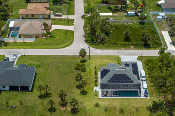 Residential house in USA with rooftop covered with solar photovoltaic panels for producing of clean ecological electrical energy in suburban rural area. Concept of autonomous home
