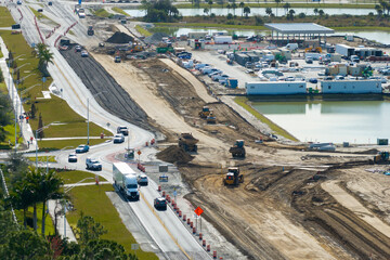Roundabout intersection construction in North Port, Florida. Development of American road circle with moving traffic cars. Urban circular transportation crossroads