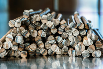 Stack of smooth steel rods on an industrial metal surface