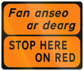 Temporary warning road sign used in Ireland - Stop Here on Red in Gaelic and English