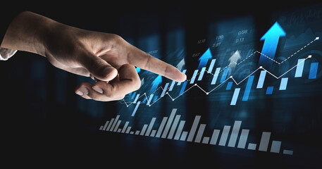A close-up of a hand pointing at evolving financial graphs displaying growth and progress in business, representing success and data analysis in a digital environment. Scalp