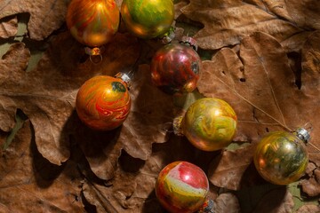 Winter mood- toys for decorating the Christmas tree on a background of oak leaves