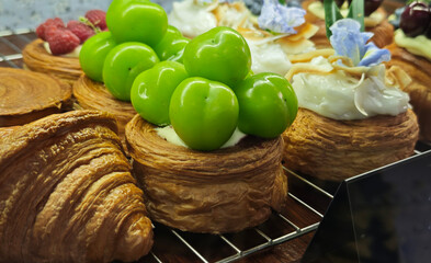 Freshly baked pastries topped with whipped cream and fresh Muscat grapes.
