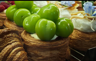 Freshly baked pastries topped with whipped cream and fresh Muscat grapes.