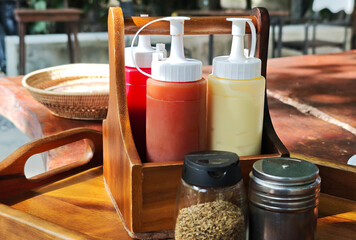 A set of seasonings: oregano, paprika, and tomato sauce in bottles.