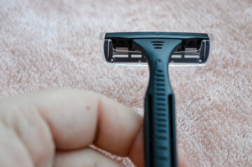 Obraz premium Close-up of a disposable razor on a soft towel. Concepts: personal hygiene, grooming routine, skincare, shaving products, bathroom essentials.