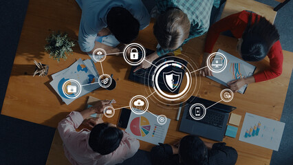 A diverse team collaborates on a cybersecurity strategy, analyzing data and utilizing technology icons in a modern workspace, promoting innovative solutions. Trope