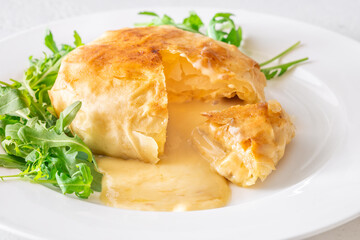 Melted Camembert en Cro&ucirc;te with rosemary garnish and vibrant cranberry sauce accompaniment