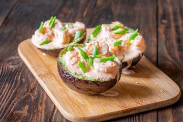 Avocado halves filled with guacamole and shrimp topped with spicy sriracha mayo