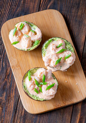 Avocado halves filled with guacamole and shrimp topped with spicy sriracha mayo