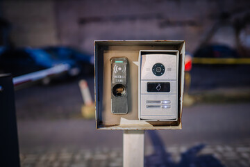 Access control panel with intercom system and keypad, mounted on a post, featuring modern design elements, illuminated at night, showcasing security technology and functionality