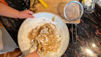Child and Parent Mixing Dough for Homemade Christmas Gingerbread Cookies Together