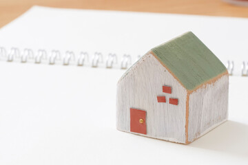 家づくりノートと木製の住宅模型