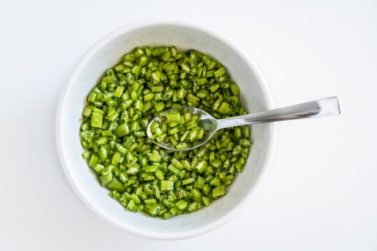 Vibrant fresh cluster beans are chopped into small uniform pieces, ready for cooking
