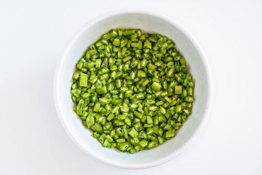 Vibrant fresh cluster beans are chopped into small uniform pieces, ready for cooking