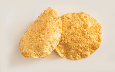 Two golden-fried Kerala-style pappadams, traditional lentil crackers, are featured against a plain white background