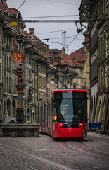 Red tram and arcades under festive lights in the Old Town Bern, Switzerland