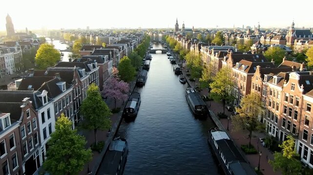 Breathtaking aerial view of a historic canal lined with classic European architecture and houseboats during golden hour