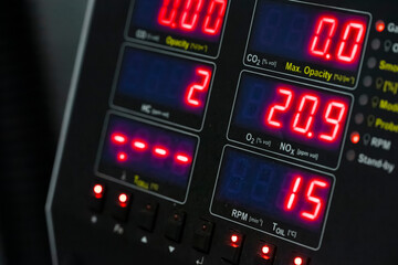 Professional emissions testing equipment with multiple digital displays showing comprehensive vehicle diagnostic data readings