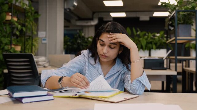 Stressed Indian student experiencing headache while studying for exams
