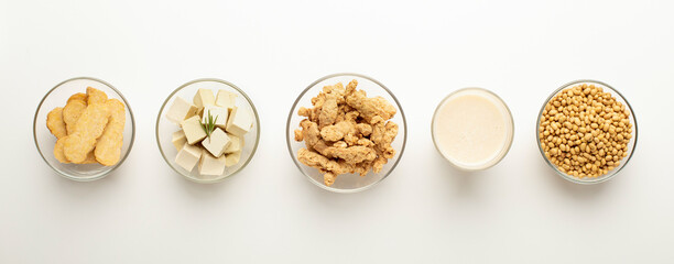 Soy food swaps. Soybeans, soy milk, soymeat, tofu and tempeh in bowls on white background, panorama