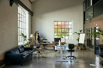New tech startup office interior with computers on desks and large windows